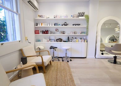 Inside Hair by Rhie in Surry Hills, New South Wales, AU. Modern salon with chic seating and well-stocked product shelves.