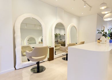 Sleek, modern interior of Hair by Rhie in Surry Hills, New South Wales, AU with stylish seating and mirrors.
