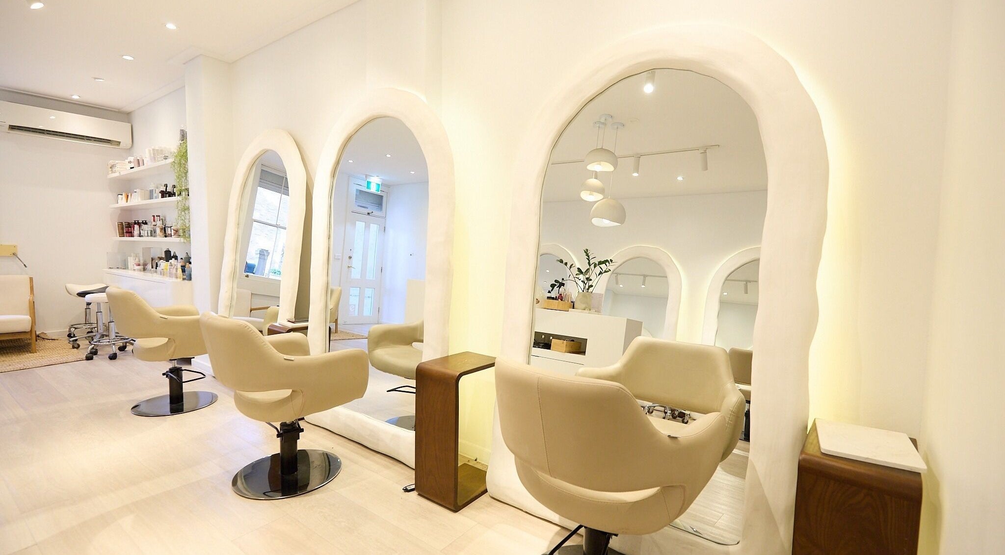 Elegant salon interior at Hair by Rhie, Surry Hills, New South Wales, AU, showcasing sleek chairs and mirrors.