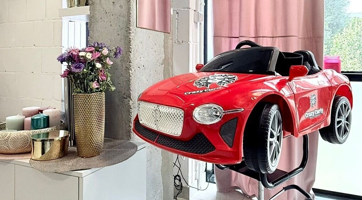 Fotel dziecięcy w formie czerwonego auta w Crazy Curly Fryzjer Wilanów - Beata Stańczak, Warszawa, Województwo Mazowieckie, PL.