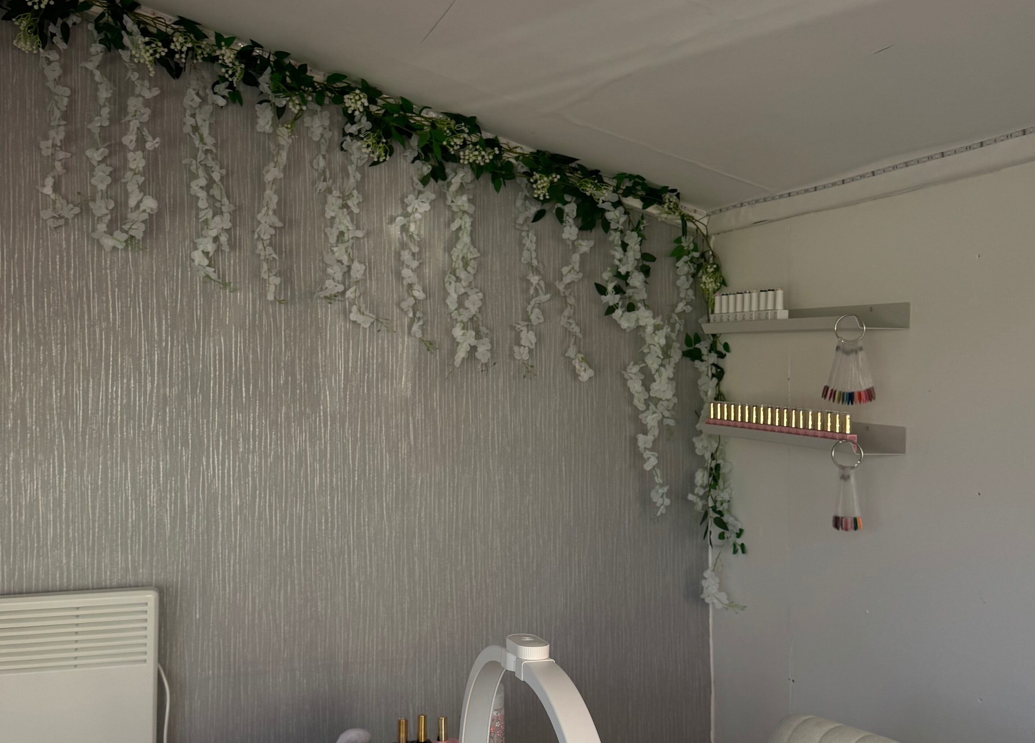Elegant wall decor with floral garland at By KatyAlice, Kippax, England, GB. A serene beauty and wellness venue.