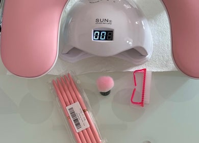 Balkan Glam Nails in London, England, GB features a UV LED lamp and pink nail tools for manicures.
