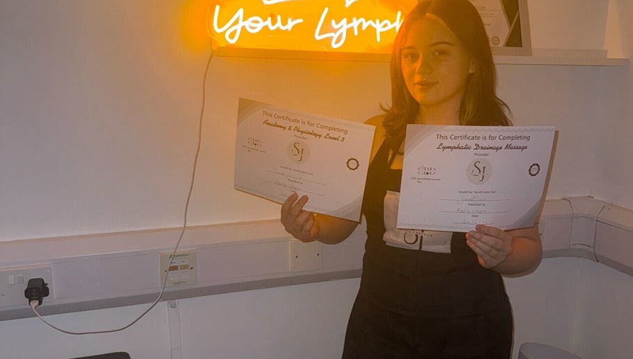 Individual holding certificates at vibrantSculpt in Knowsley, England, GB showcasing achievement.