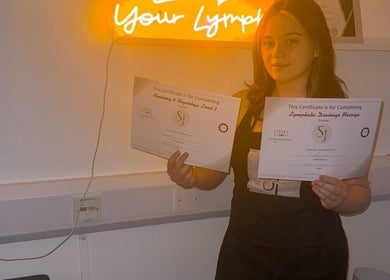 Individual holding certificates at vibrantSculpt in Knowsley, England, GB showcasing achievement.
