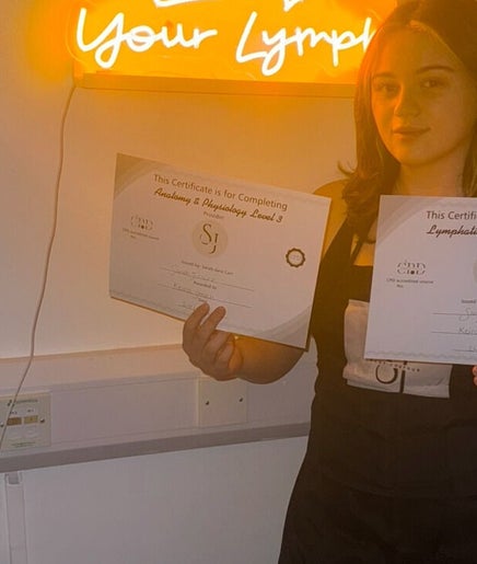 Individual holding certificates at vibrantSculpt in Knowsley, England, GB showcasing achievement.