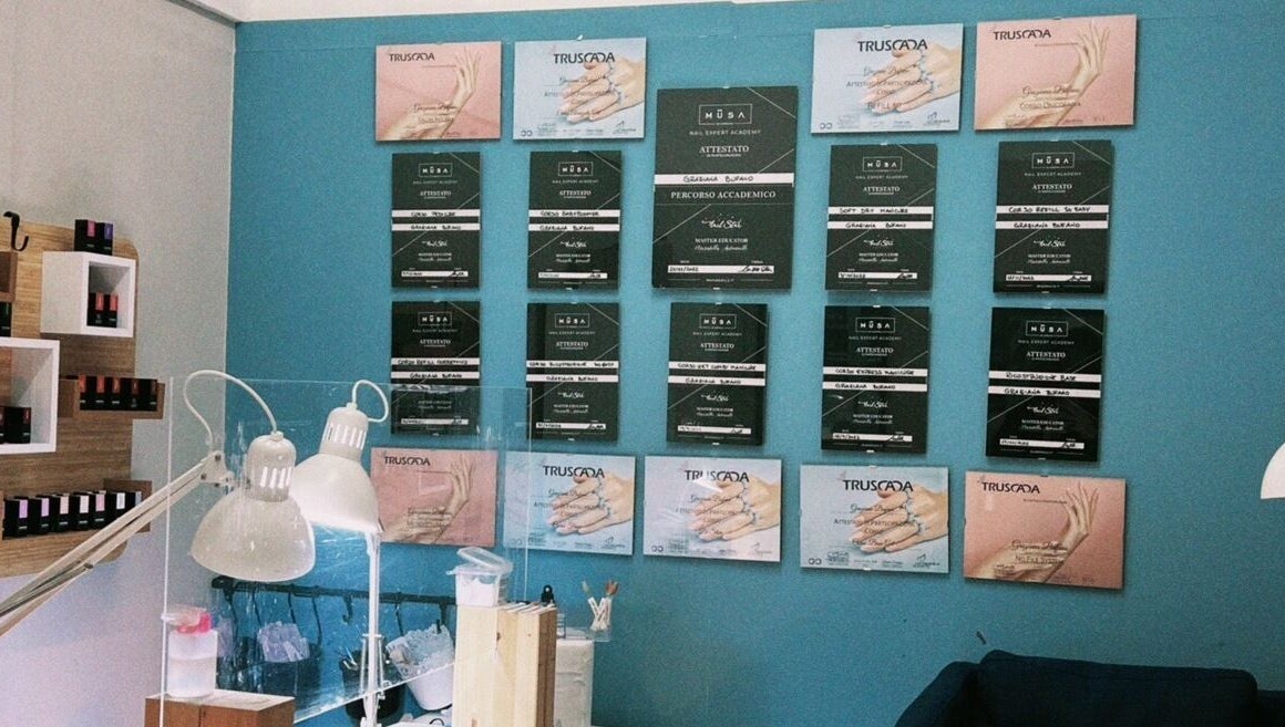 Interno di Grazianaildecor a Massafra, Puglia, con parete di attestati e illuminazione moderna.