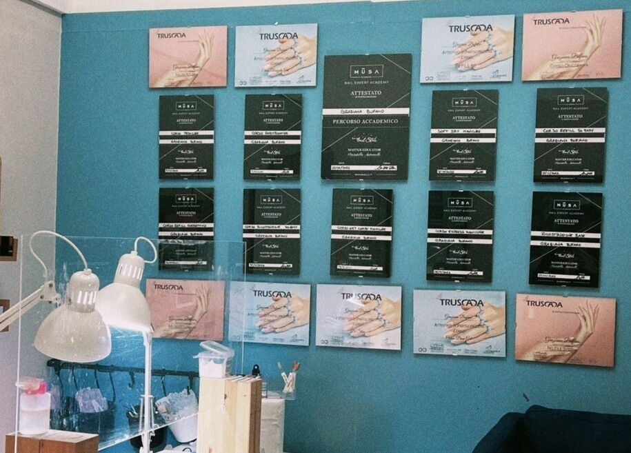 Interno di Grazianaildecor a Massafra, Puglia, con parete di attestati e illuminazione moderna.