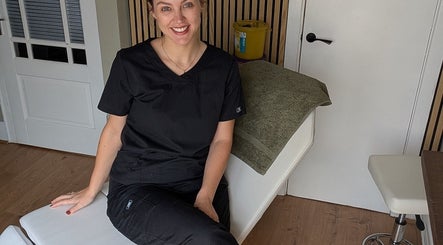 Professional at Recentre Aesthetics, Stockport, England, GB, sitting in a tranquil treatment room.