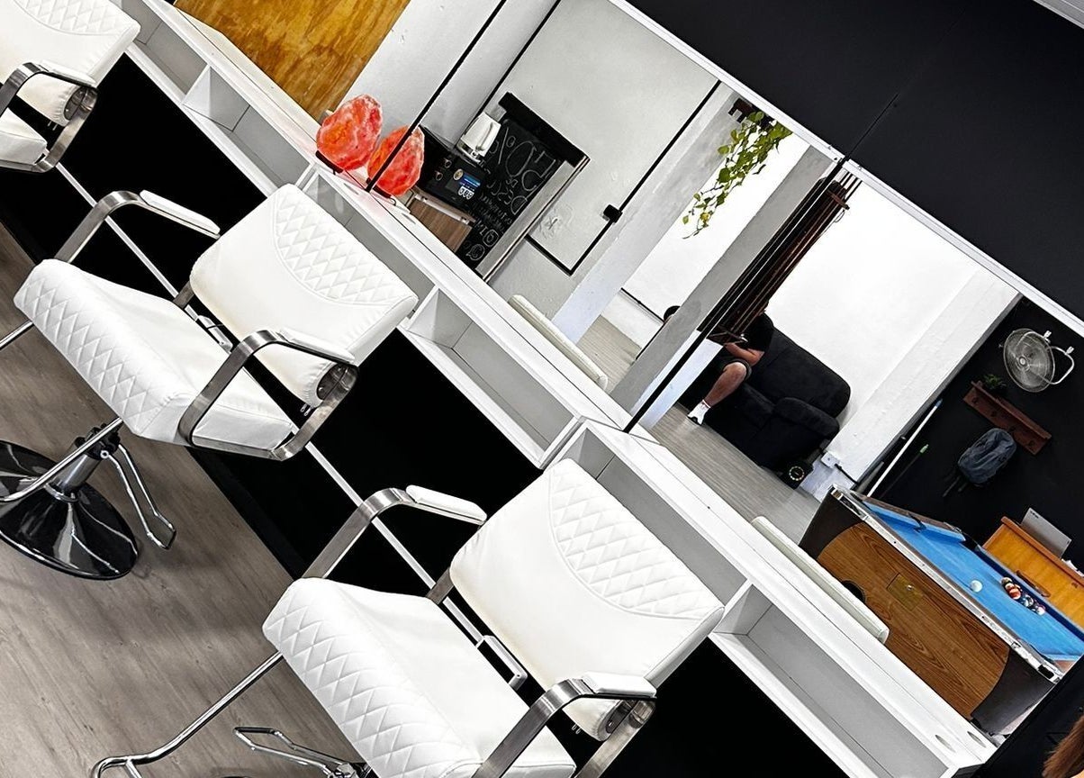 Interior moderno de Impakto en Atlántida, Departamento De Canelones, UY, con sillas blancas frente a un espejo.