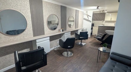 Stylish hairdressing station at Hair By Mel in Exning, England, GB with elegant mirrors and sleek chairs.