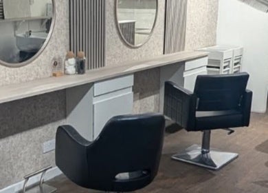 Modern salon interior at Hair By Mel, Exning, England. Features stylish seating and mirrors.