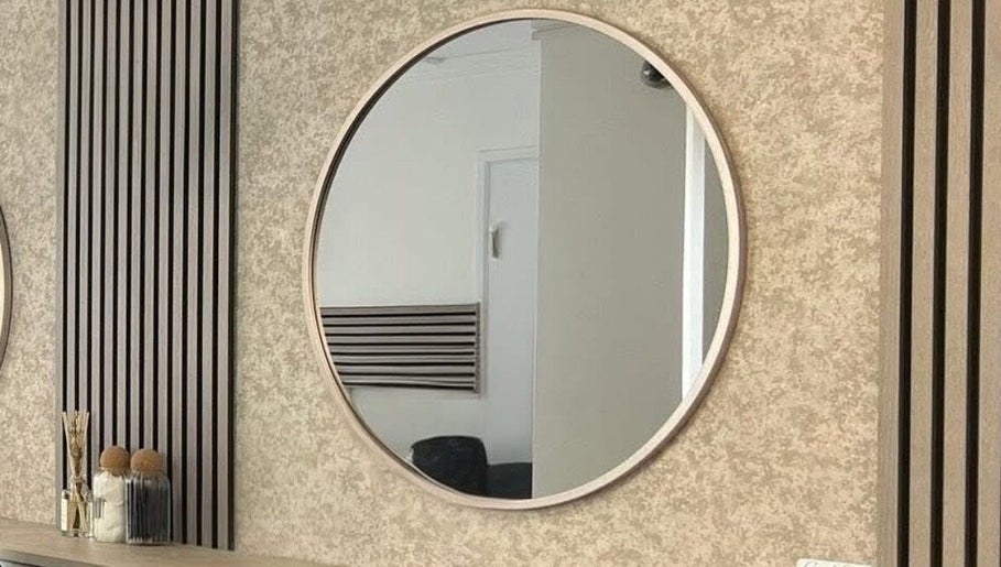 Modern round mirror at Hair By Mel, Exning, England, GB enhances salon's sleek decor.