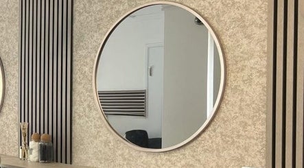 Modern round mirror at Hair By Mel, Exning, England, GB enhances salon's sleek decor.