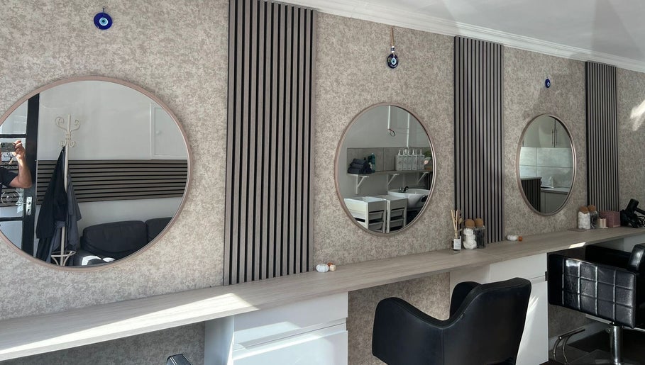 Modern salon interior at Hair By Mel, Exning, England, GB, featuring stylish mirrors and seating.