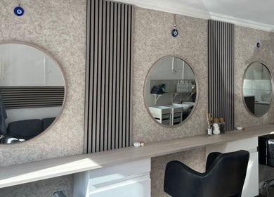 Modern salon interior at Hair By Mel, Exning, England, GB, featuring stylish mirrors and seating.