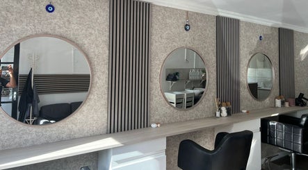 Modern salon interior at Hair By Mel, Exning, England, GB, featuring stylish mirrors and seating.