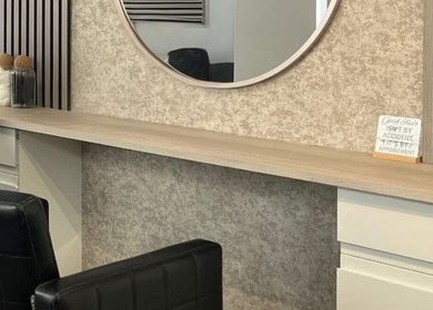 Modern salon interior at Hair By Mel in Exning, England, GB with stylish mirrors and seating.