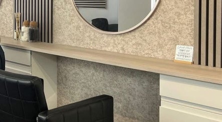 Modern salon interior at Hair By Mel in Exning, England, GB with stylish mirrors and seating.