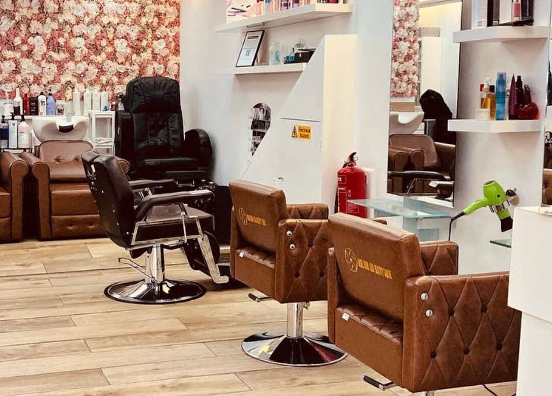 Stylish interior of Ariel Hair & Beauty in London, England, GB showing salon chairs and floral wall decor.