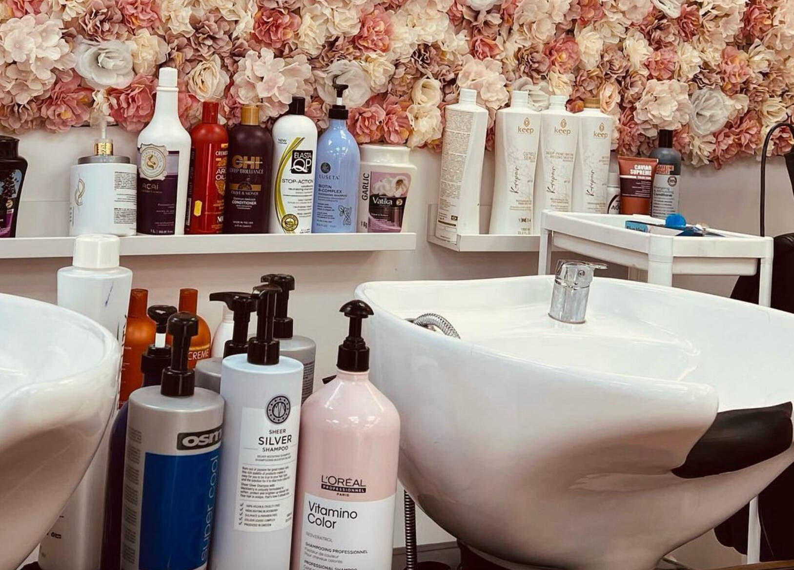 Shampoo station at Ariel Hair & Beauty, London, England, GB with floral decor and salon products.