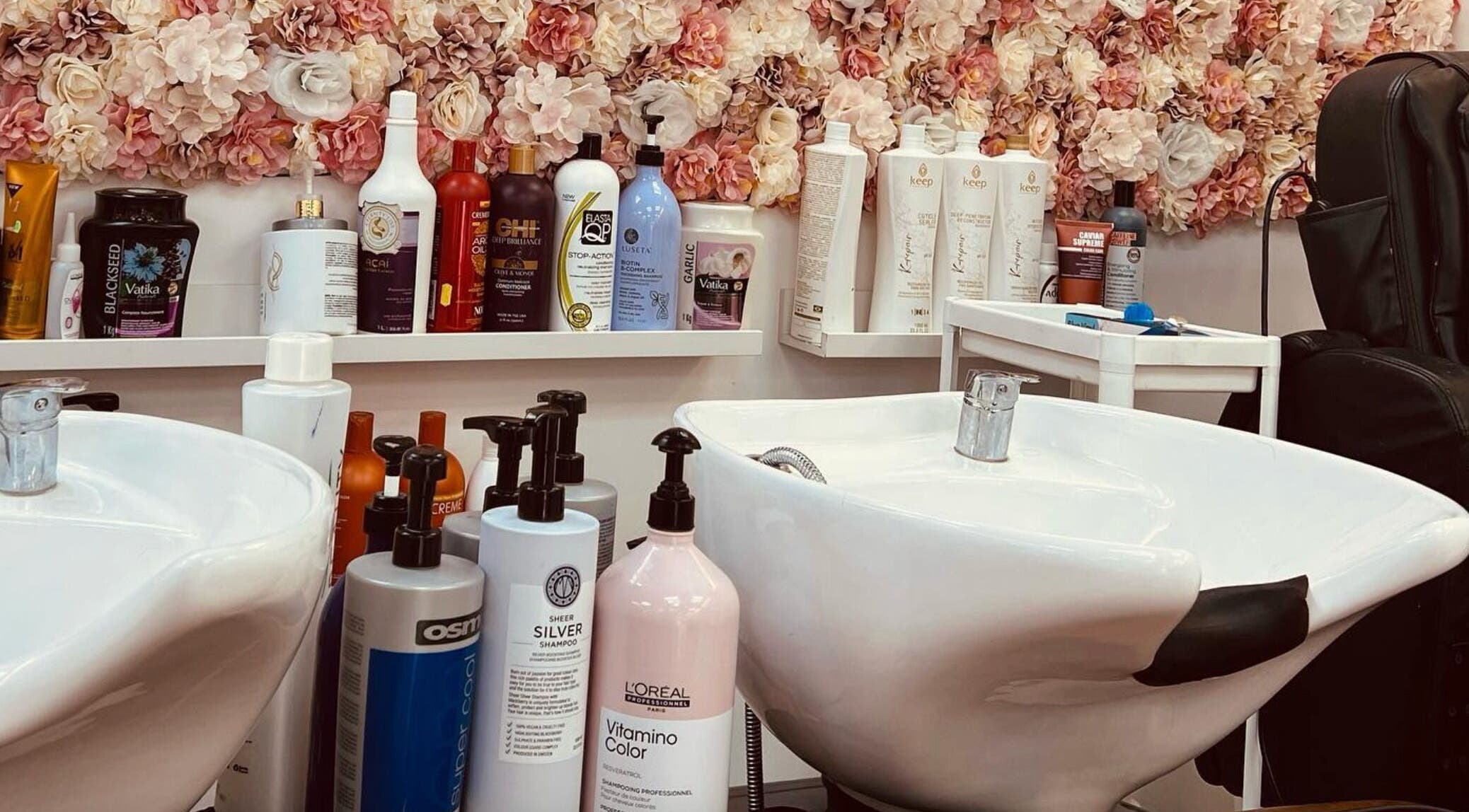 Shampoo station at Ariel Hair & Beauty, London, England, GB with floral decor and salon products.