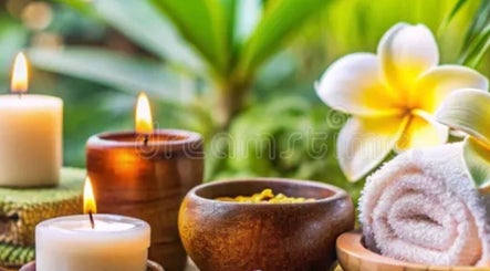 Zen spa scene with candles, plumeria, and rolled towel at Dessa Therapist, Grantham, England, GB.