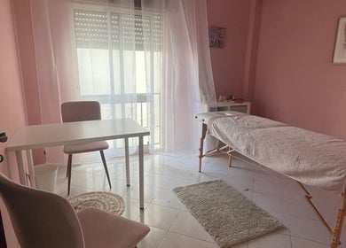 Sala de terapia com maca em A Tua Hipno, Faro, Faro, PT, decorada em tons suaves de rosa claro.