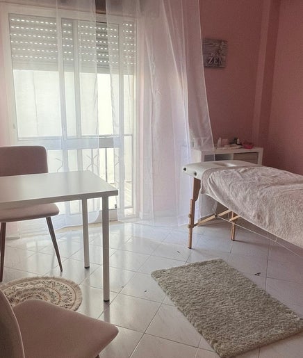 Sala de terapia com maca em A Tua Hipno, Faro, Faro, PT, decorada em tons suaves de rosa claro.