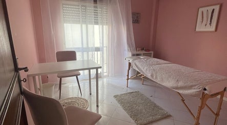 Sala de terapia com maca em A Tua Hipno, Faro, Faro, PT, decorada em tons suaves de rosa claro.