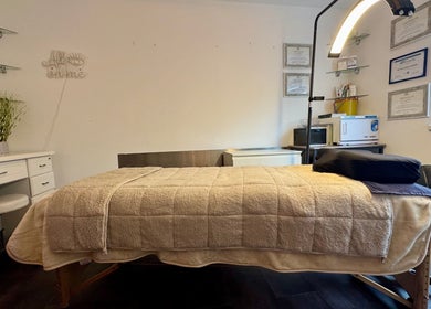Relaxing treatment room at Beauty by Jessica in Cheltenham, England, GB with cozy bedding and warm lighting.