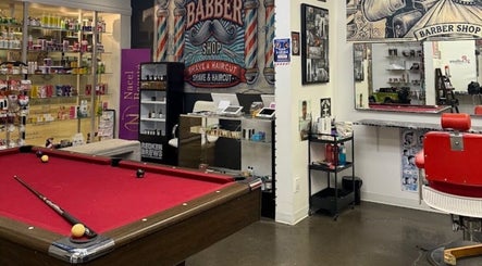Intérieur rétro de barber shop chez Lockness by Maya, Trois-Rivières, Québec, CA, avec billard et fauteuils.
