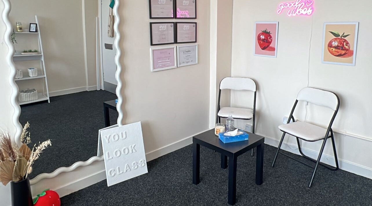 Bright waiting area at Embody Beauty, Clydebank, Scotland, GB with decor and seating.