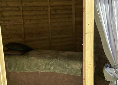 Relaxing massage area at The Massage Room, Atherstone, England, GB with soft bedding and wood interior.