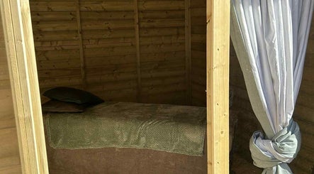 Relaxing massage area at The Massage Room, Atherstone, England, GB with soft bedding and wood interior.