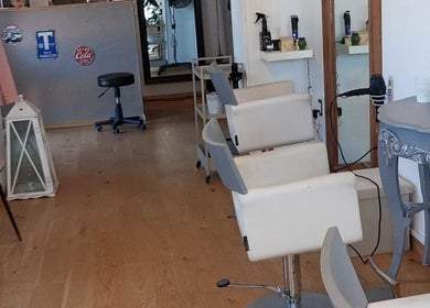 Interno elegante del Parrucchieri Roma,132 a Lazio, Lazio, IT con poltrone bianche e specchi raffinati.