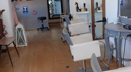 Interno elegante del Parrucchieri Roma,132 a Lazio, Lazio, IT con poltrone bianche e specchi raffinati.