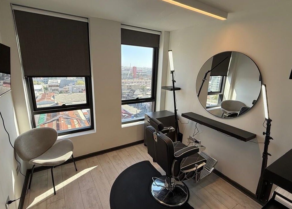 Elegante salón de belleza en VIBRA STUDIO, Concepción, Bío Bío, CL, con sillas modernas y vista panorámica.