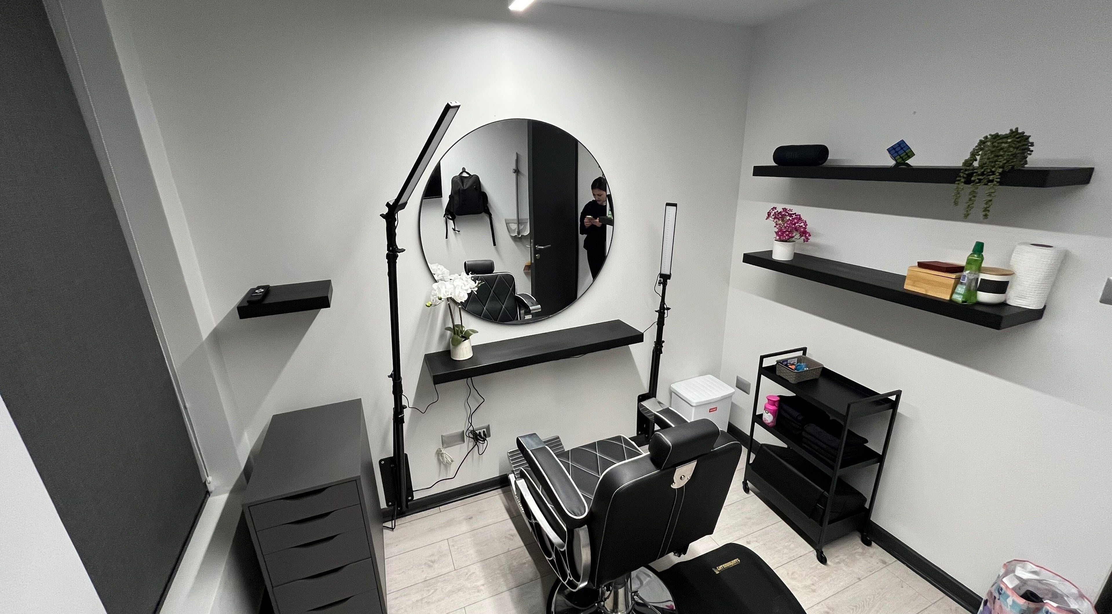 Salón moderno en VIBRA STUDIO, Concepción, Bío Bío, CL, con silla de barbero y espejo redondo.