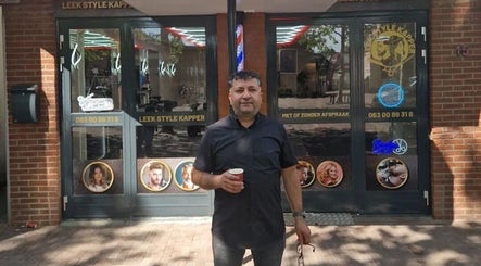 Owner standing outside Leek Style Kapper in Leek, Groningen, NL on a sunny day.