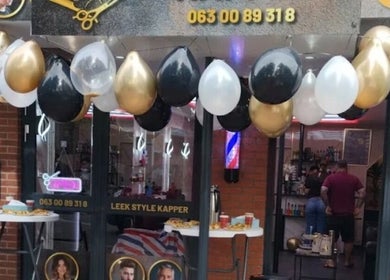 Entrance of Leek Style Kapper in Leek, Groningen, NL decorated with black, gold, and white balloons.