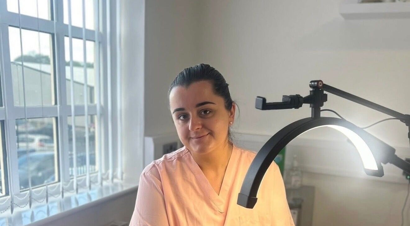 Expert beautician at Pure SKNN, Warrington, England, providing skincare treatments under professional lighting.