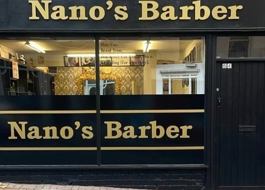 Front view of Nanos Barber in Enniscorthy, County Wexford, IE, showcasing stylish black and gold signage.