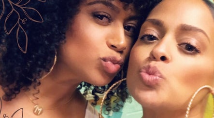 Two smiling women at Prink’d Haus in New York, exuding beauty and style with curly hairstyles.