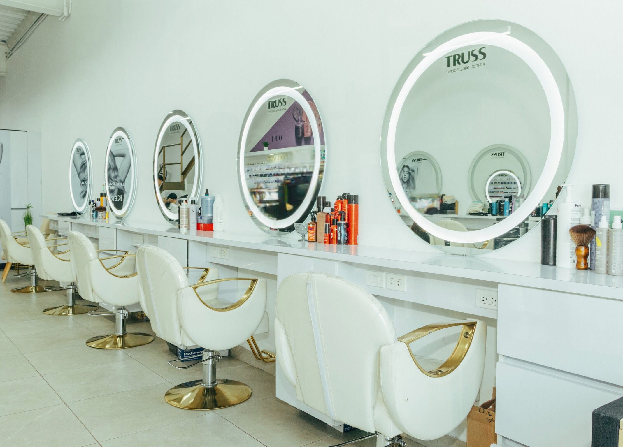 Interior moderno de Prime Salon | Obarrio en Panamá, Provincia De Panamá, PA con espejos iluminados y sillas elegantes.