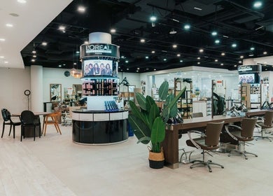 Modern interior of Kimage Salon in Singapore, featuring stylish chairs and plant decor for a relaxing ambiance.