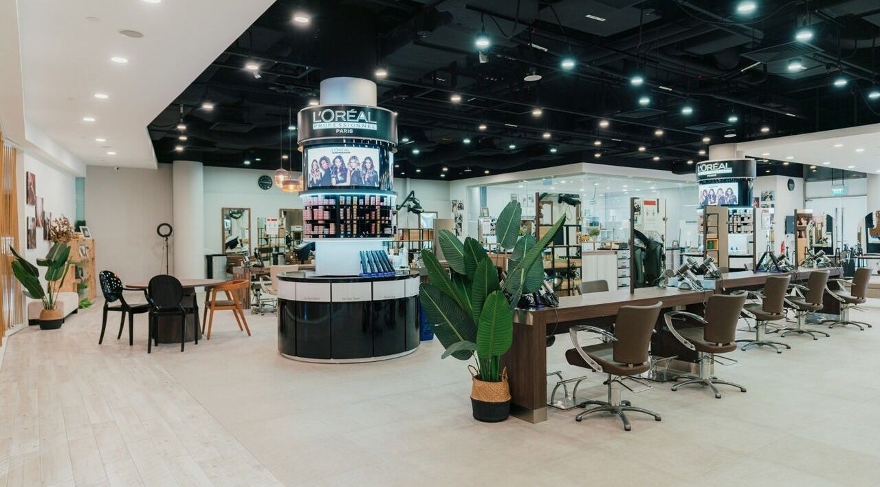 Modern interior of Kimage Salon in Singapore, featuring stylish chairs and plant decor for a relaxing ambiance.