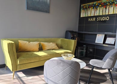 Cozy seating area in Seoul Hair salon, Calgary, Alberta, CA, with yellow sofa and wall art.