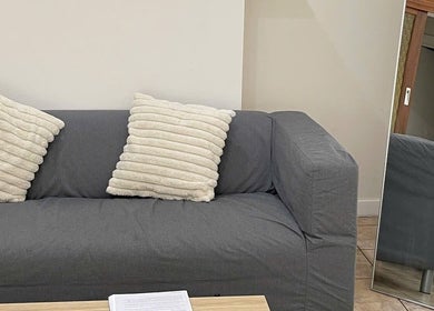 Plush gray sofa with pillows in cozy lounge at Mira Lash, Parafield Gardens, South Australia, AU.