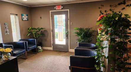 Cozy lobby of Immanuel Acupressure Nature Spa in Rockville, Maryland, US with lush greenery and seating.