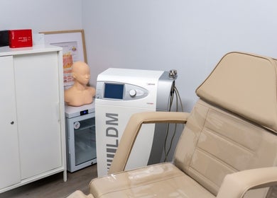 Treatment room at Nudia Skin Clinic, Melbourne, Victoria, AU with a beige chair and aesthetic equipment.